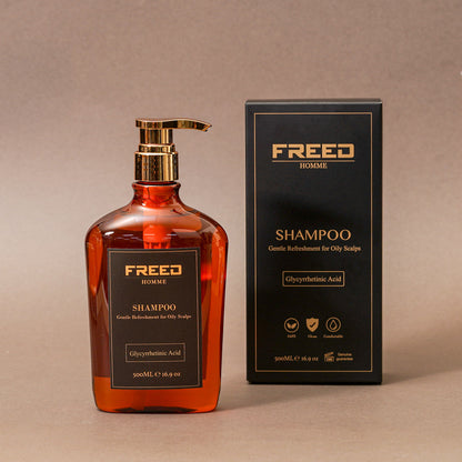 琥珀色瓶身，與黑色禮盒並列，FREED 客製化刻字。