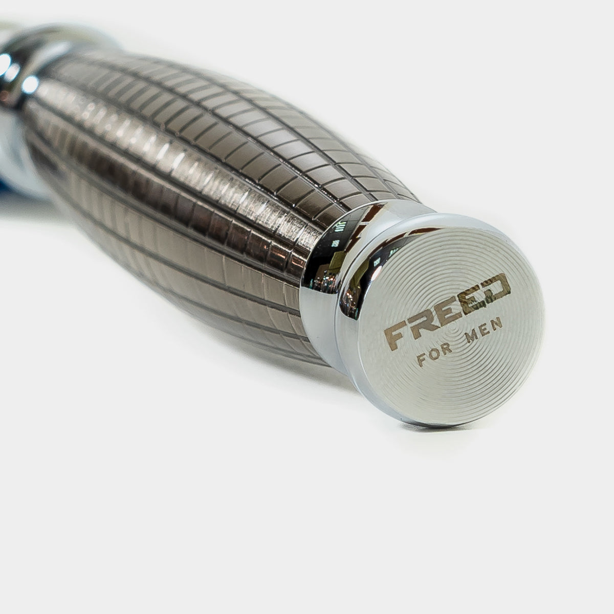 金屬銀色手雷款刮鬍刀，近拍攝影，FREED 客製化刻字。